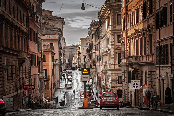 Rome, Italy - January 18, 2025: The picture captures an electronic road sign in Rome displaying ZTL attiva - a message that the Zona a Traffico Limitato is currently active. ZTLs are restricted traffic zones used by Italian cities to limit vehicle access during set hours. Entry by non-authorized vehicles can trigger camera enforcement and fines. These restrictions aim to reduce congestion, noise, and emissions while preserving historic districts for residents, public transport, delivery windows, and pedestrians. The image explains the concept through the illuminated display, situating it on a busy urban street where cars, shops, and older buildings frame the notice of access control.
