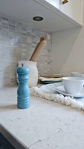 istock Blue pepper mill stands prominently on a marble kitchen countertop with rolling pin and dishware, creating a cozy culinary atmosphere 2233260423