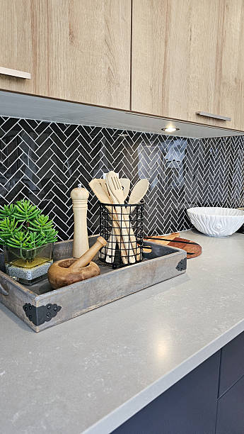 istock Modern kitchen countertop featuring stylish utensils in a decorative tray, with herringbone backsplash and natural elements enhancing the culinary space 2233260429
