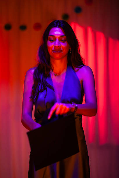 istock Elegant woman in dim red lighting holding a document 2233261877
