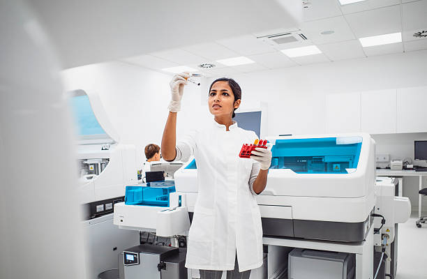 istock Focused Young Female Lab Technician Examining Sample in Modern Laboratory with Bright Lighting 2233262080