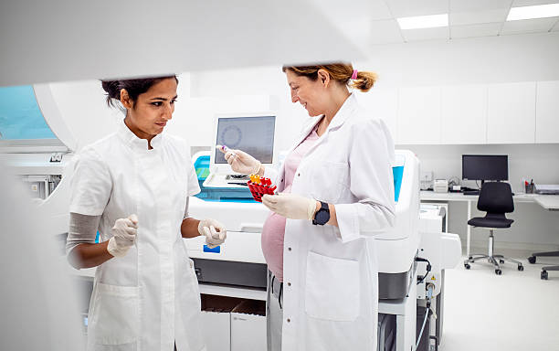 istock Pregnant Medical Researcher And Indian Lab Technician Examining Samples In Modern Laboratory 2233262090