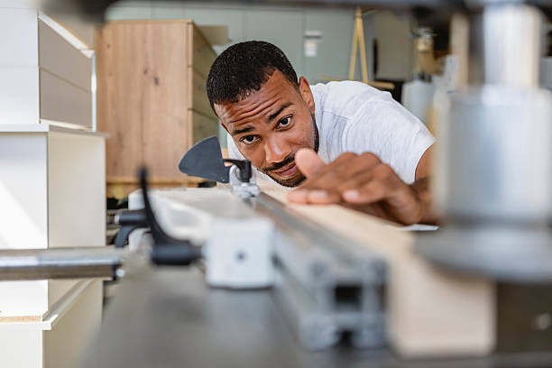 istock Focused Mid-Adult Multiracial Carpenter Aligning Wood with Precision in Workshop 2233262381