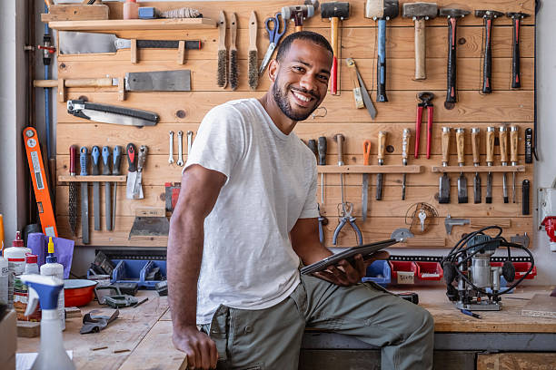 istock Smiling Multiracial Male Carpenter in Bright Workshop Holding Tablet in Casual White T-Shirt 2233262425