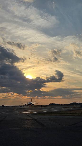 istock Dramatic Sky Over Airport with Airplane Silhouette 2233268040