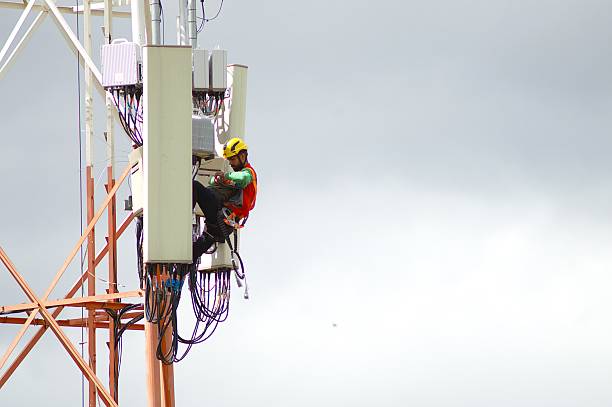 istock Central maintenance: technician seated on telecom tower amid antenna modules during field service in Brazil 2233270219