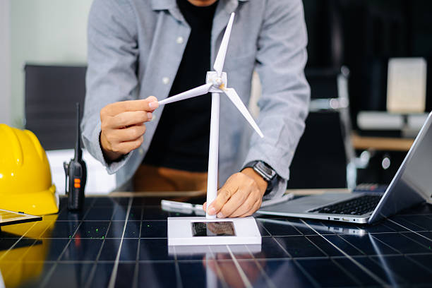 istock Engineer using tablet near solar panel and wind turbine model, representing clean energy, green innovation, and smart technology 2233272062
