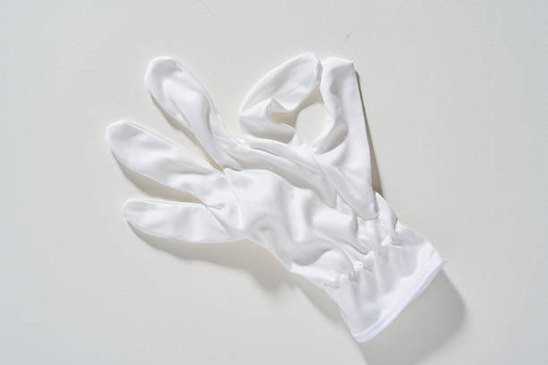 Closeup of new, mass produced, leather work gloves on a wood background.