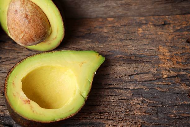 istock Fresh avocado halves on wooden backgrou 2233273979