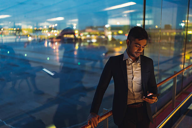 istock Asian businessman making a call before flight departure during dusk 2233277413