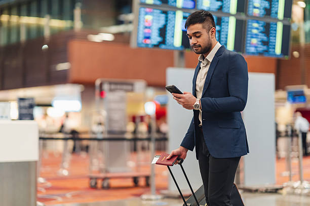 istock Asian man checking his mobile phone for flight updates at the airport 2233277483