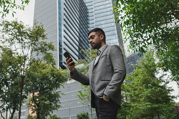 istock Asian businessman using his phone while commuting to work in the business district 2233277498