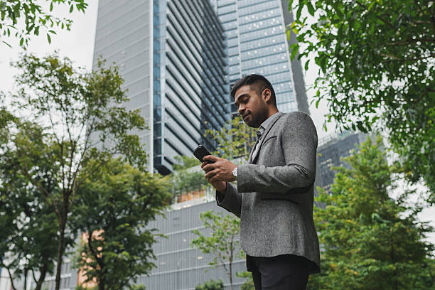 istock Asian businessman using his phone while commuting to work in the business district 2233277501