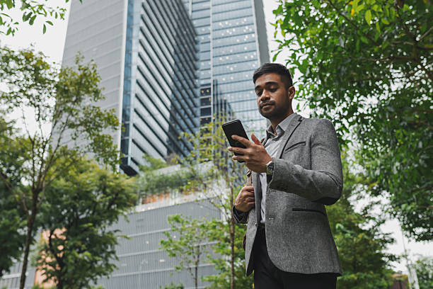 istock Asian businessman using his phone while commuting to work in the business district 2233277506