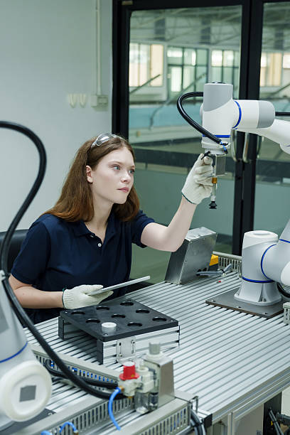 istock female engineer adjusting robotic system in smart factory during robotics automation training wearing protective glove and safety glasses monitoring machine accuracy on production table 2233277878