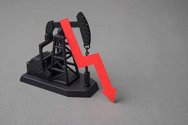 istock Crude oil pumpjack with red falling prices chart on grey background copy space. 2233279726
