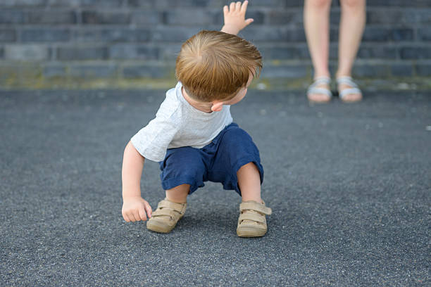 istock Toddler Reaching Toward Standing Woman 2233281450