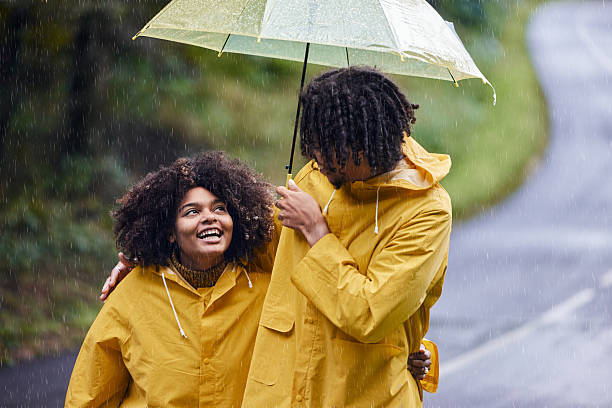istock Happy black couple walking embraced under umbrella on rainy day. 2233285701