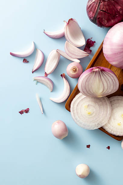 Fresh Sliced Onions and Red Skins on Blue Background Surface