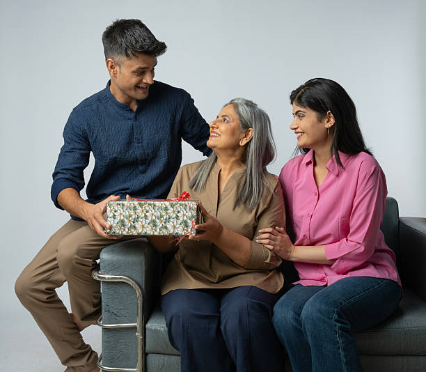 istock Family with gift box sitting on sofa against white background 2233287678