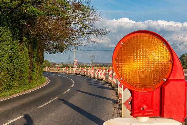 istock Yellow warning light on a beacon to indicate a roadworks site in a blind bend on the right-hand side of the road 2233289082