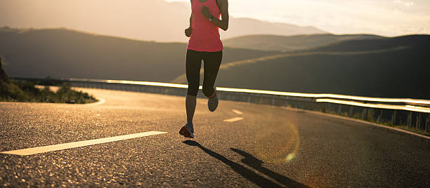 istock Woman runner running in sunset mountain road 2233289813