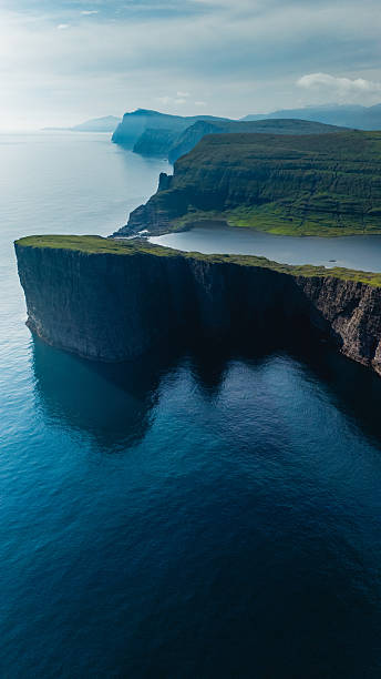 istock Dramatic cliffs and serene waters of the Faroe Islands under soft sunlight 2233290347