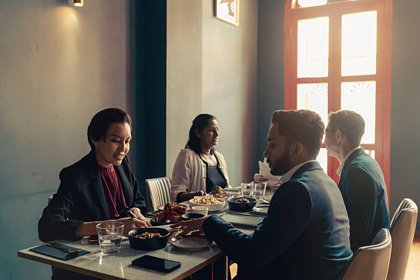 Diverse and multiracial Asian team working during business lunch