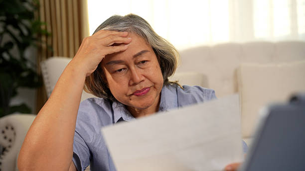 istock Senior woman feeling stressed over numerous bills on the table 2233292423