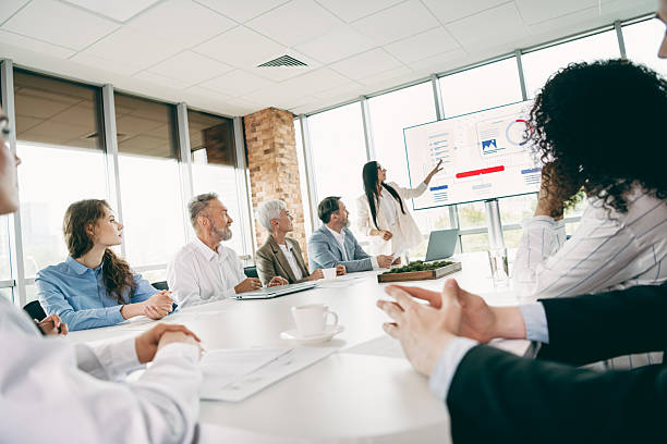 istock Professional team members collaborating in an office setting during a business presentation with charts and graphs displayed 2233293110