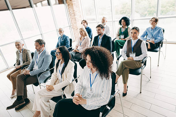 istock Corporate event attendees seated attentively at a conference in a modern office setting with professional, diverse participants 2233293185