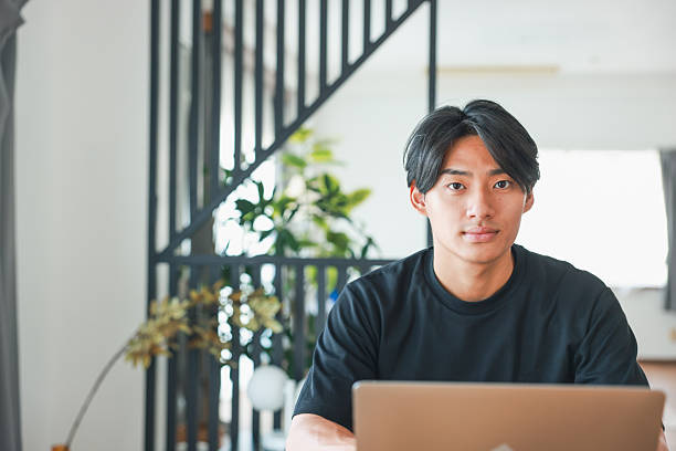 istock Young Asian Man Looking At Camera Indoors 2233298221