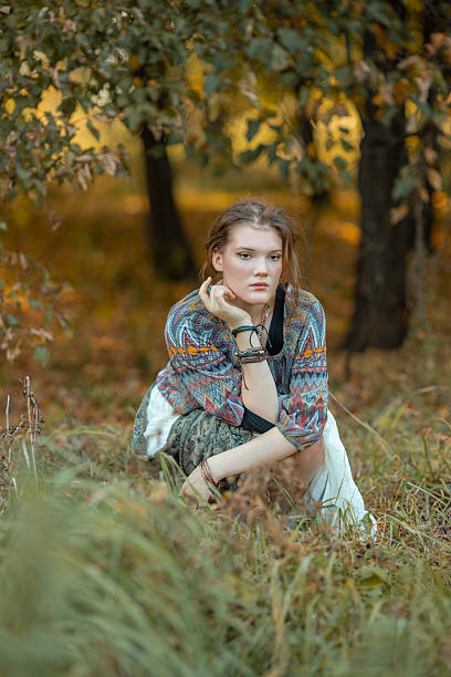 istock Young woman in boho style clothes posing in autumn forest 2233299028