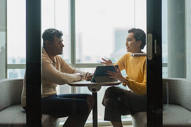 istock Asian agent pitching to a prospective client in a privacy pod 2233301709