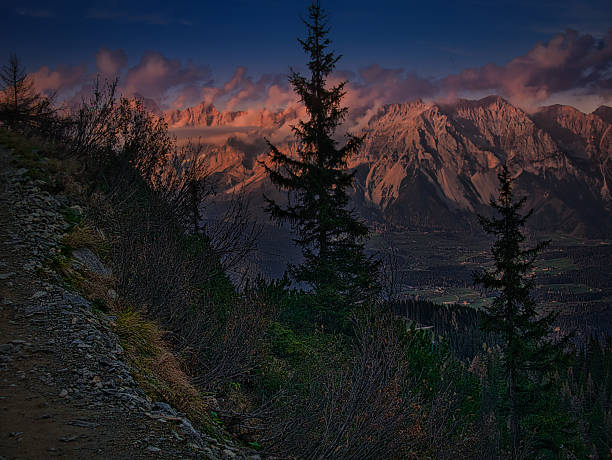 View from mountains on scenic mountain autumn/fall landscape with rocks and cliffs of a Dachstein massive, trees, clouds, sky. Mountains around Schladming-Dachstein resort, Austria.