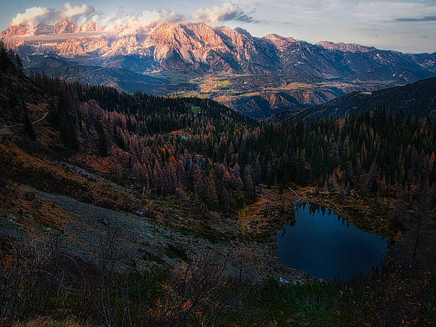 Scenic mountain autumn/fall landscape with a mountain lake, rocks, cliffs, trees, water surface during autumn. Mystique  relaxing  nature. Mountains around Schladming-Dachstein resort, Austria.
