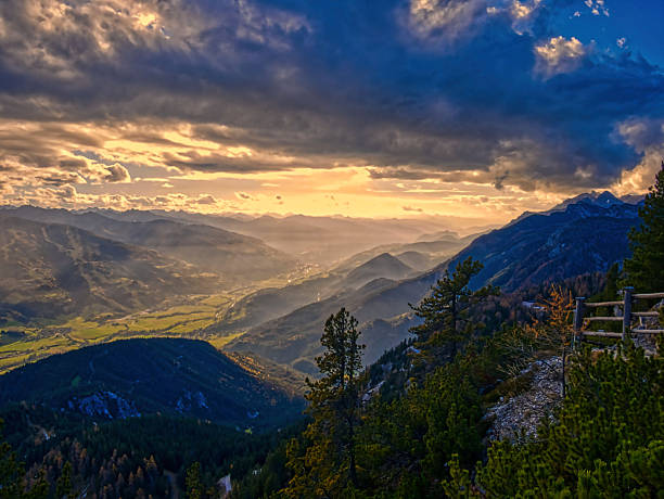 View from mountains on scenic mountain autumn/fall landscape with rocks and cliffs from a Stoderzinken mountain, trees, clouds, sky.  Mountains around Schladming-Dachstein resort, Austria.