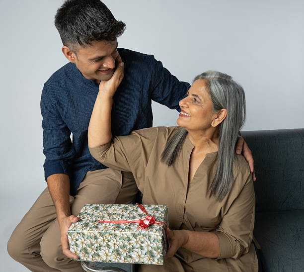 istock Family with gift box sitting on sofa against white background 2233303664