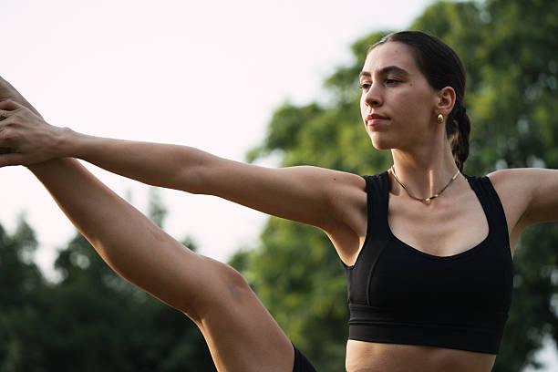 istock Young woman practicing extended hand to big toe pose outdoors 2233304754