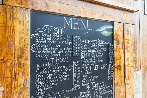Chalkboard restaurant menu with handwritten items and prices in a rustic wooden frame outside a cafe. Wareham, UK, 3 July 2024