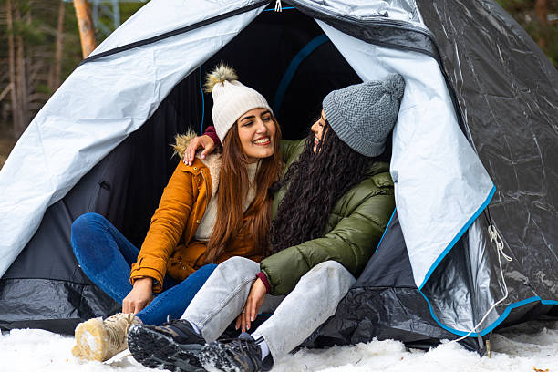 istock Two smiling women camping inside tent during winter 2233306033
