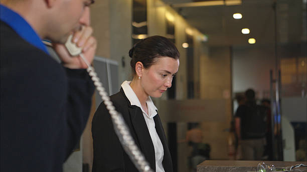 Young woman at front desk talking on the phone.
