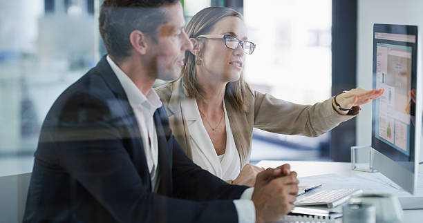 istock Team, computer and business people in office for proposal, budget chart or brainstorming solution. Meeting, planning or pointing at screen with advisor for stats, financial review or discussion 2233307043