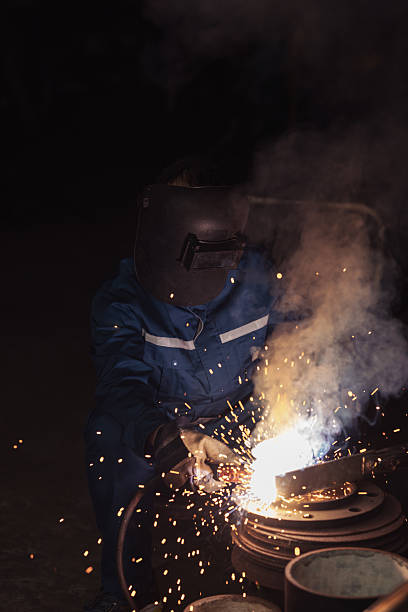 istock Industrial worker with safety equipment operating a welding procedure 2233307770