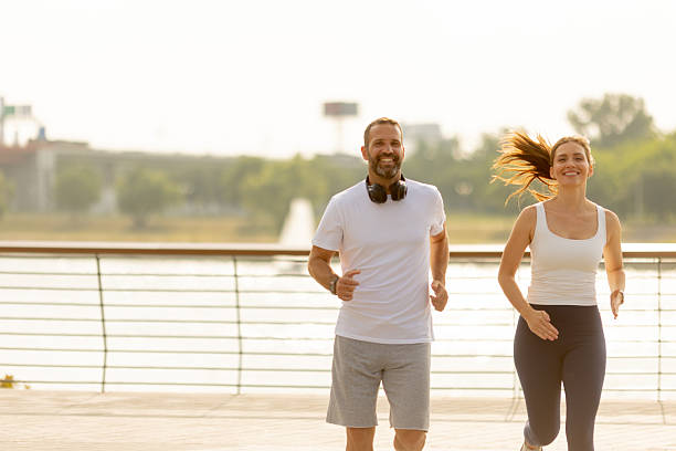istock Running enthusiasts enjoy a sunny morning along the waterfront pathway 2233308946