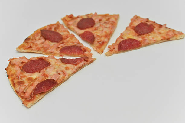 pepperoni pizza slices arranged together on white background. pizza pieces form tempting display of melted cheese and salami topping. pizza food concept is ideal for fast food advertising and menus.