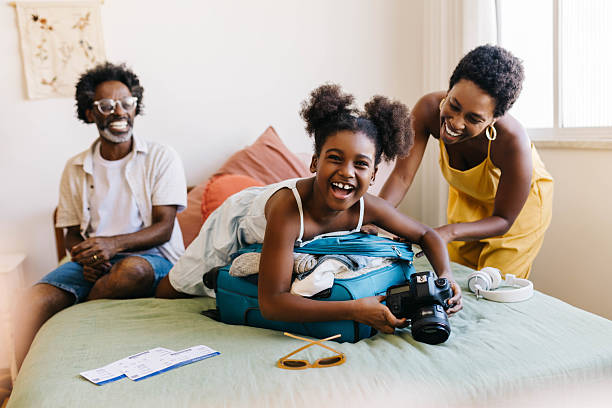 istock Excited daughter holding camera while travel packing with her parents 2233313619