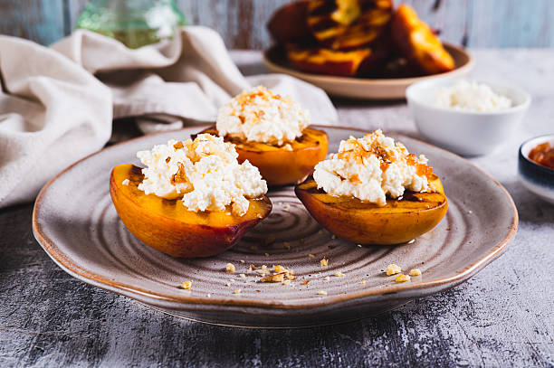 istock Grilled peach halves with ricotta and nuts on a plate on the table 2233314537