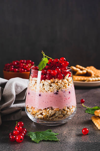 Cheesecake with red currant in a glass on the table vertical view