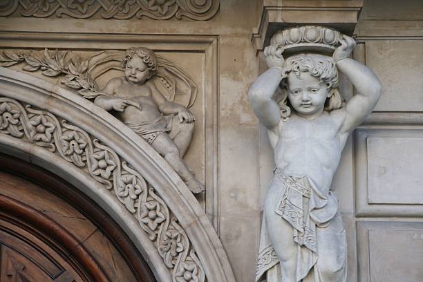 Close up of a small angel carved in the top, internal part of the portal of the church of Santi Vincenzo e Anastasio a Trevi,  a Baroque church rebuilt in 1650 in Rome.
